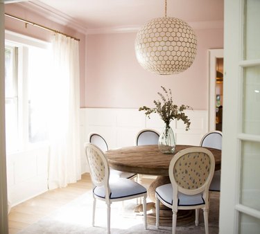 traditional pink dining room idea with white wainscoting