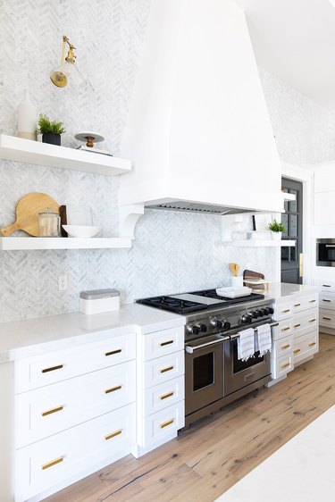 Modern kitchen idea with large white hood and tile backsplash