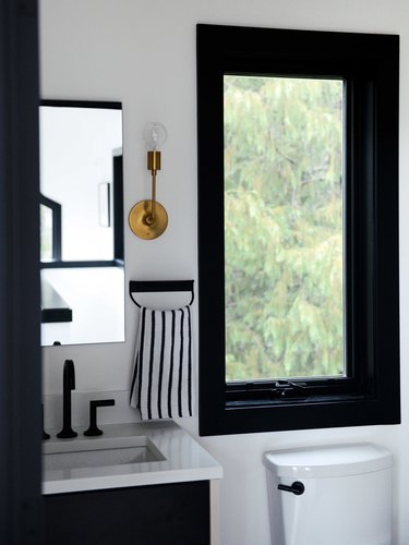 black and white bathroom with deck-mounted faucet on small vanity