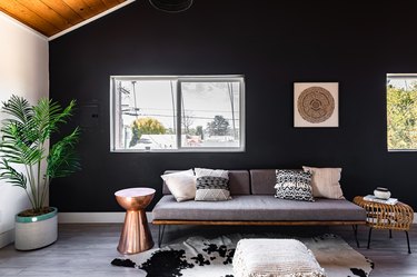 charcoal gray paint colors in living room with wood ceiling, gray couch, and cowhide rug