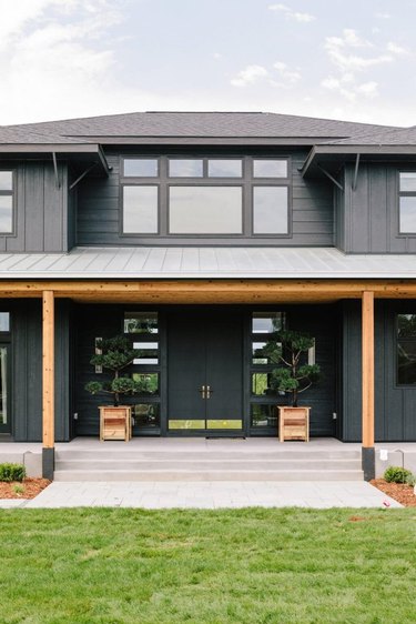 gray exterior window trim on two0level house with wood pillars and concrete porch