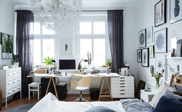 bedroom office idea with industrial desk setup along a wall of windows in a mostly-white bedroom