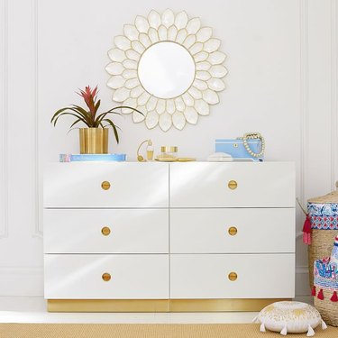 white six drawer dresser with brass base and drawer pulls