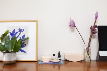 Flowers on credenza with art