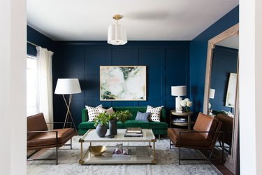 green living room idea with blue walls and velvet green sofa