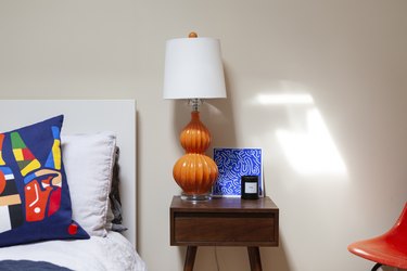 Midcentury nightstand with orange lamp