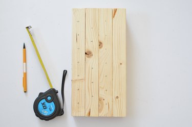 Measuring drill holes on wooden bee house