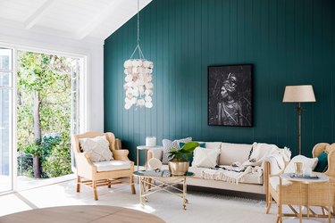 green living room idea with accent wall and rattan furniture