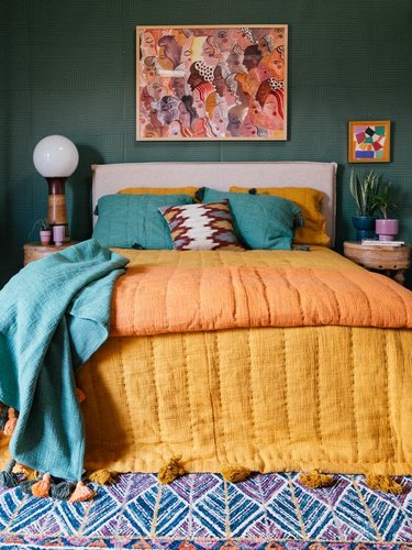 ochre color bedding in green bedroom