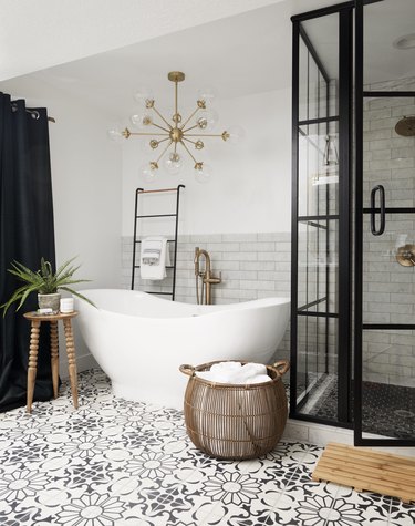 soft black and white pattern tile floor, black shower frame, and white soaking tub