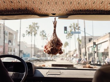 A dried bouquet hanging from a rear-view mirror