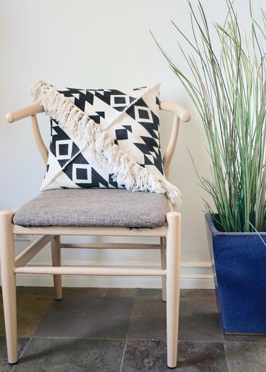 DIY Fringe Pillow Out of a Rug on wishbone chair.