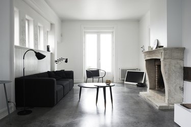 minimalist black-and-white living room idea with black sofa and stone fireplace