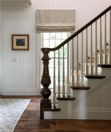 traditional staircase with wood railing and white spindles
