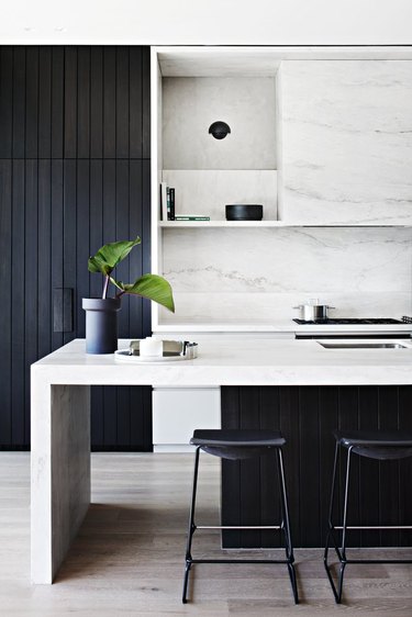 black kitchen cabinet idea with island and marble backsplash