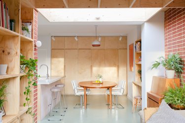 colors that go with red in a white room with plywood shelves and brick red wall