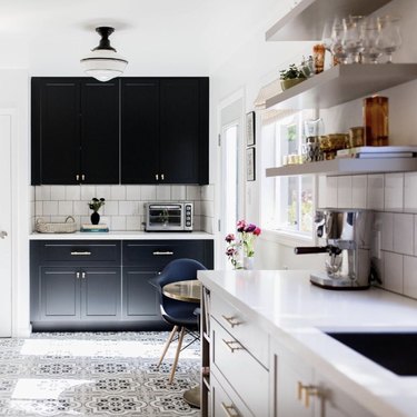 black kitchen cabinet idea for kitchen with light cabinets in the foreground and black cabinets in the background