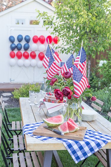 A table before a garage with American flag balloons