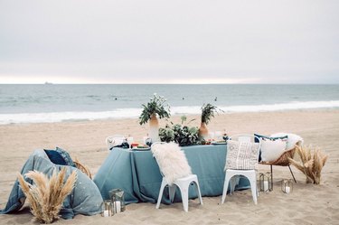A table with light blue tablecloth on a beach