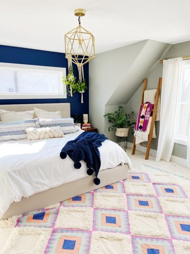 cream carpet colors in bohemian bedroom with patterned rug and blue accent wall