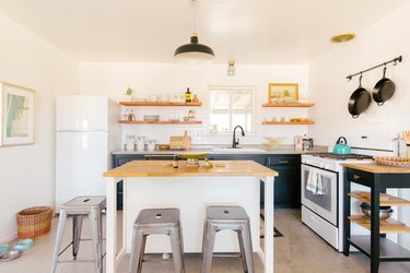 white kitchen island with stainless steel barstools