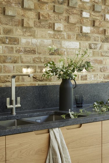 black kitchen backsplash  backsplash and black countertops with wood cabinets and brick wall