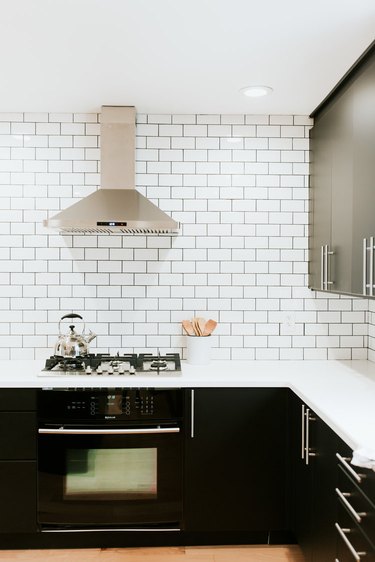 classic white subway tile kitchen backsplash with dark cabinetry