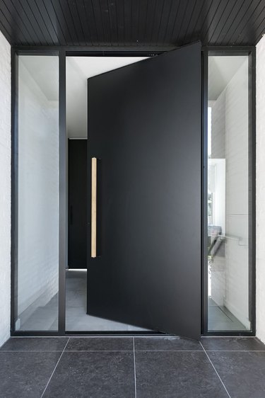 modern exterior door in matte black flanked by windows