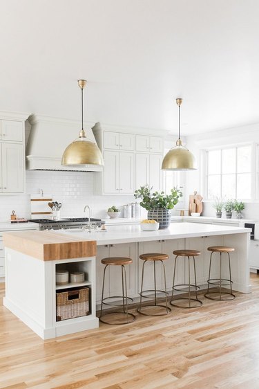 small kitchen island idea with butcherblock and white countertop with brass pendants