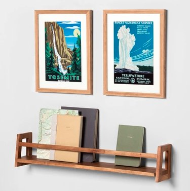 bookshelf with books and two printed frames