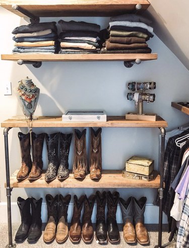 Custom industrial closet ideas with wood shelves and cowboy boots