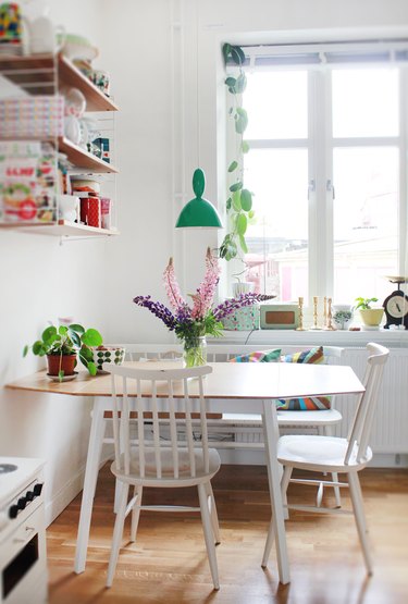 small kitchen table idea with white dining chairs and green pendant light
