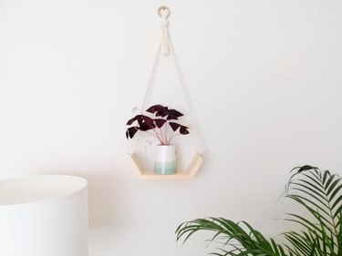 Wooden hanging shelf with macrame hanger and half-hexagonal wooden shelf