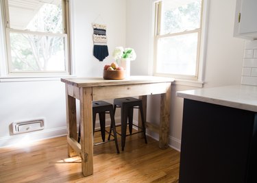 small kitchen table idea with rustic wood table and stools near windows