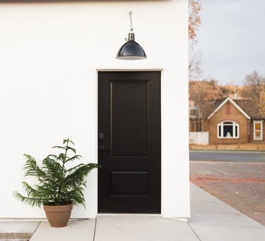 Black exterior house light on white exterior above black door