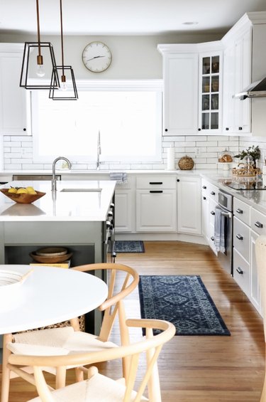 Lantern-style budget kitchen lighting with white cabinets an island with sink