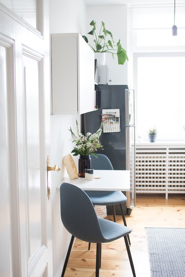 small kitchen table idea mounted to the wall with two chairs and storage above