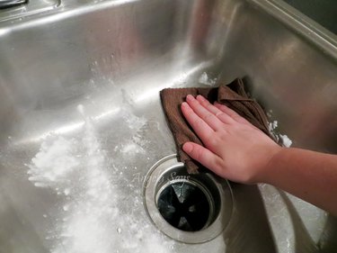 Cleaning a stainless steel sink.