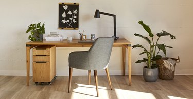 desk with gray chair and plant nearby