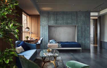 gray industrial color palette in living room with blue walled cabinets and murphy bed