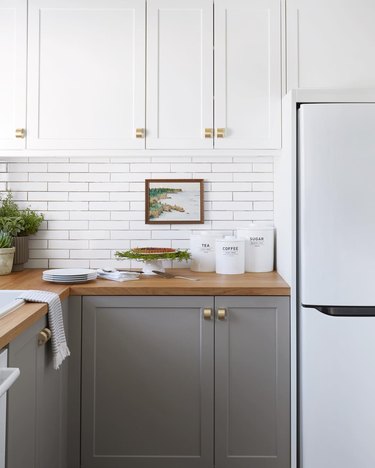 two-tone cabinet kitchen trend in 2019 with white subway tile backsplash and wood countertops
