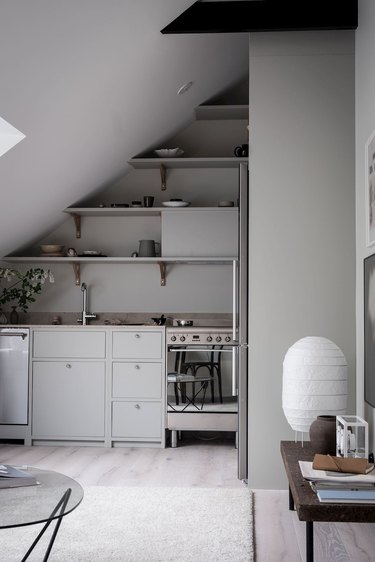 gray attic kitchen with open shelving and angled ceiling