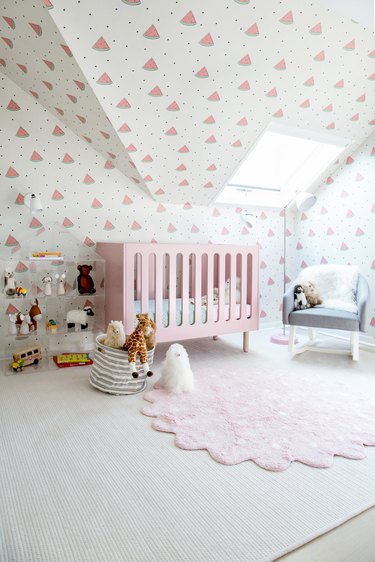 small nursery idea with wallpaper on walls and slanted ceiling