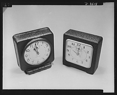 two wartime alarm clocks made of pressed wood and paper pulp