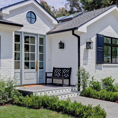 exterior door trim on white brick house with blue door and trim