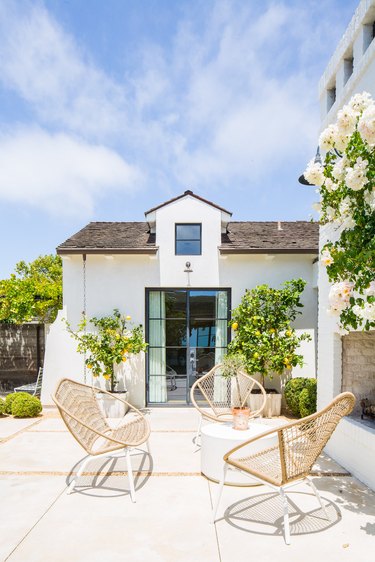 black critall exterior back doors leading onto boho patio with rattan chairs