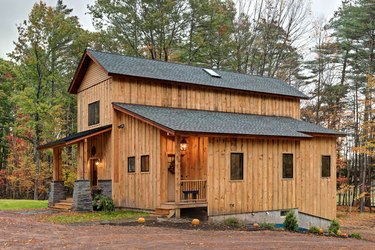 Board and batten exteriors on wood cabin with black roof