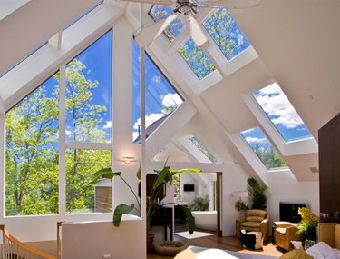 attic skylight designs in white attic with multiple windows and plants