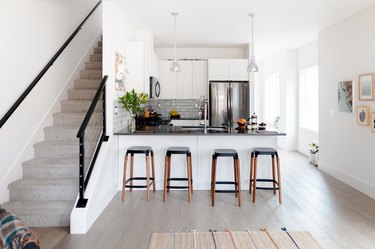 kitchen bar with counter stools near staircase