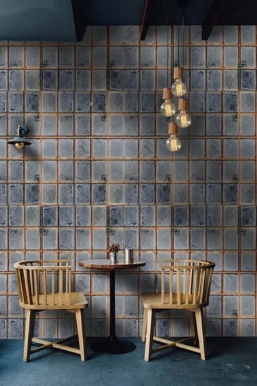 blue and gray industrial wallpaper with table and chairs in front